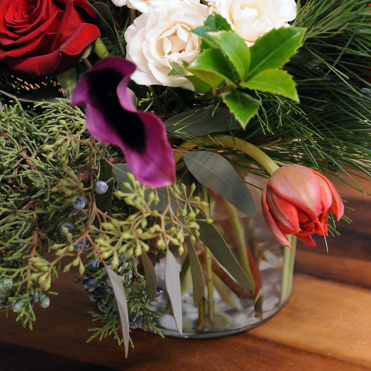 Details of roses tulips and textural holiday greens foliage