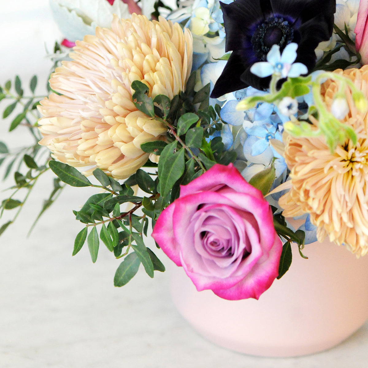 Close up detail image of Emerson arrangement showing Deep purple roses