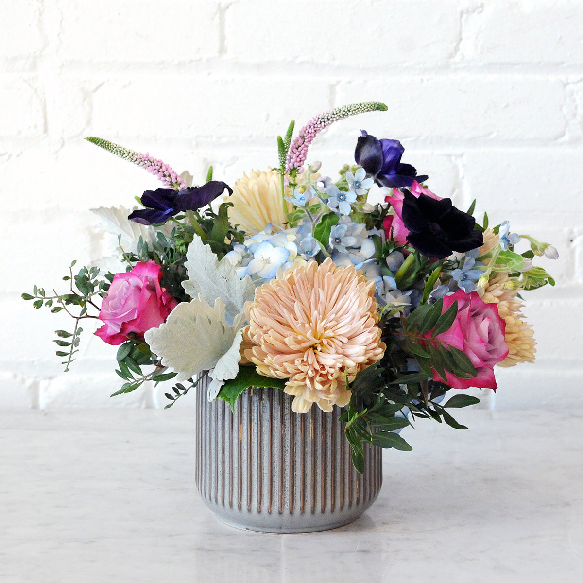 Spruce Flowers Emerson arrangement in a brown fluted ceramic vase