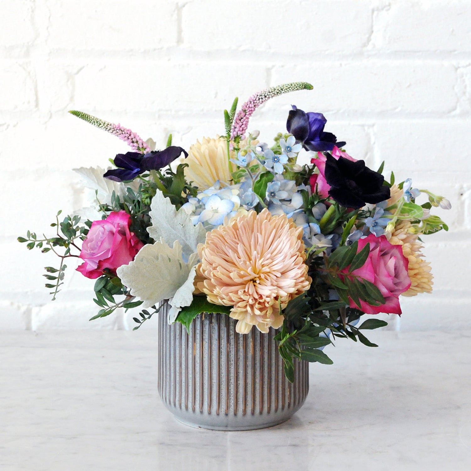 Spruce Flowers Emerson arrangement in a brown fluted ceramic vase