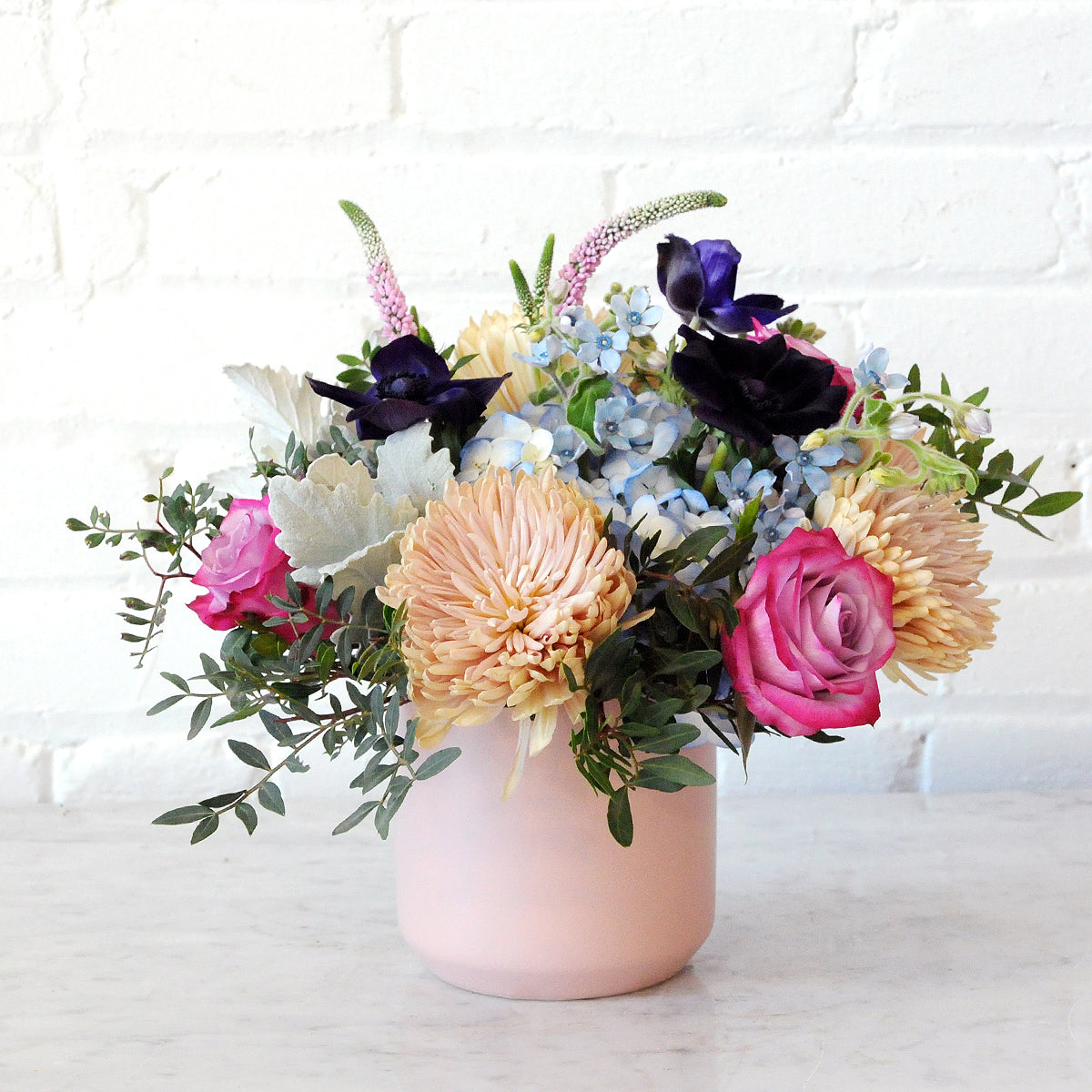 Spruce Flowers Emerson arrangement classical but with a hint of whimsy arranged in a soft pink ceramic vase