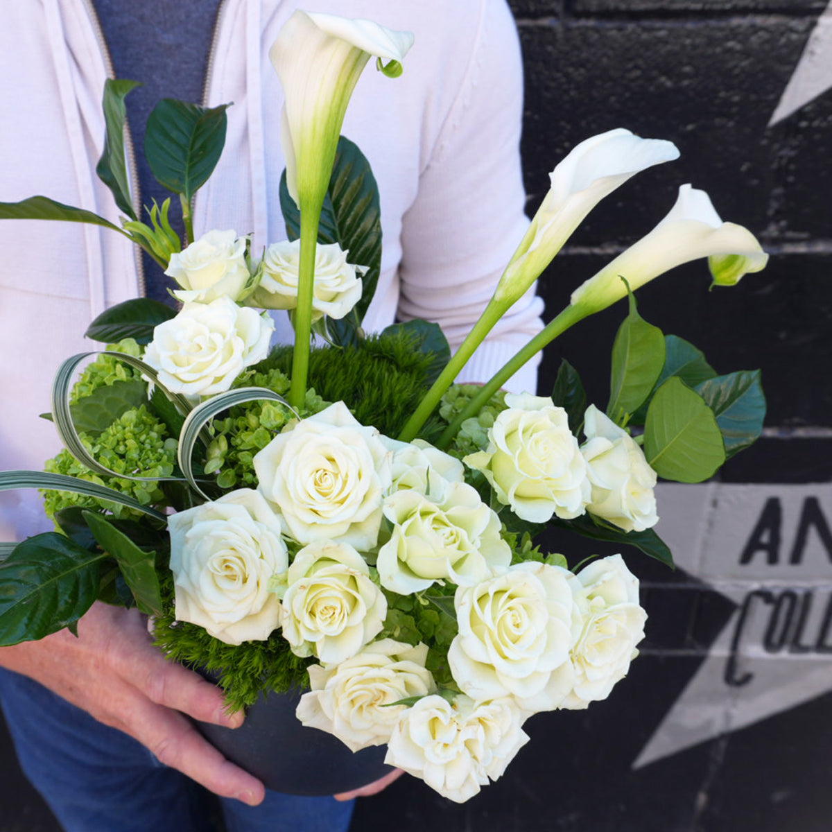 Bouquet of white flowers held by a person with a blurred background