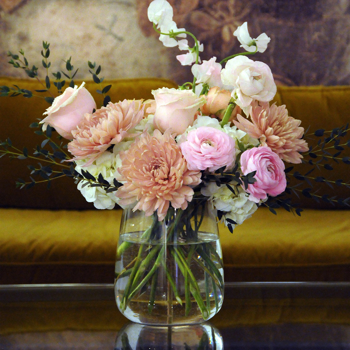 France Ave arrangement from Spruce Flowers in Minneapolis set on a table with a sofa in the background