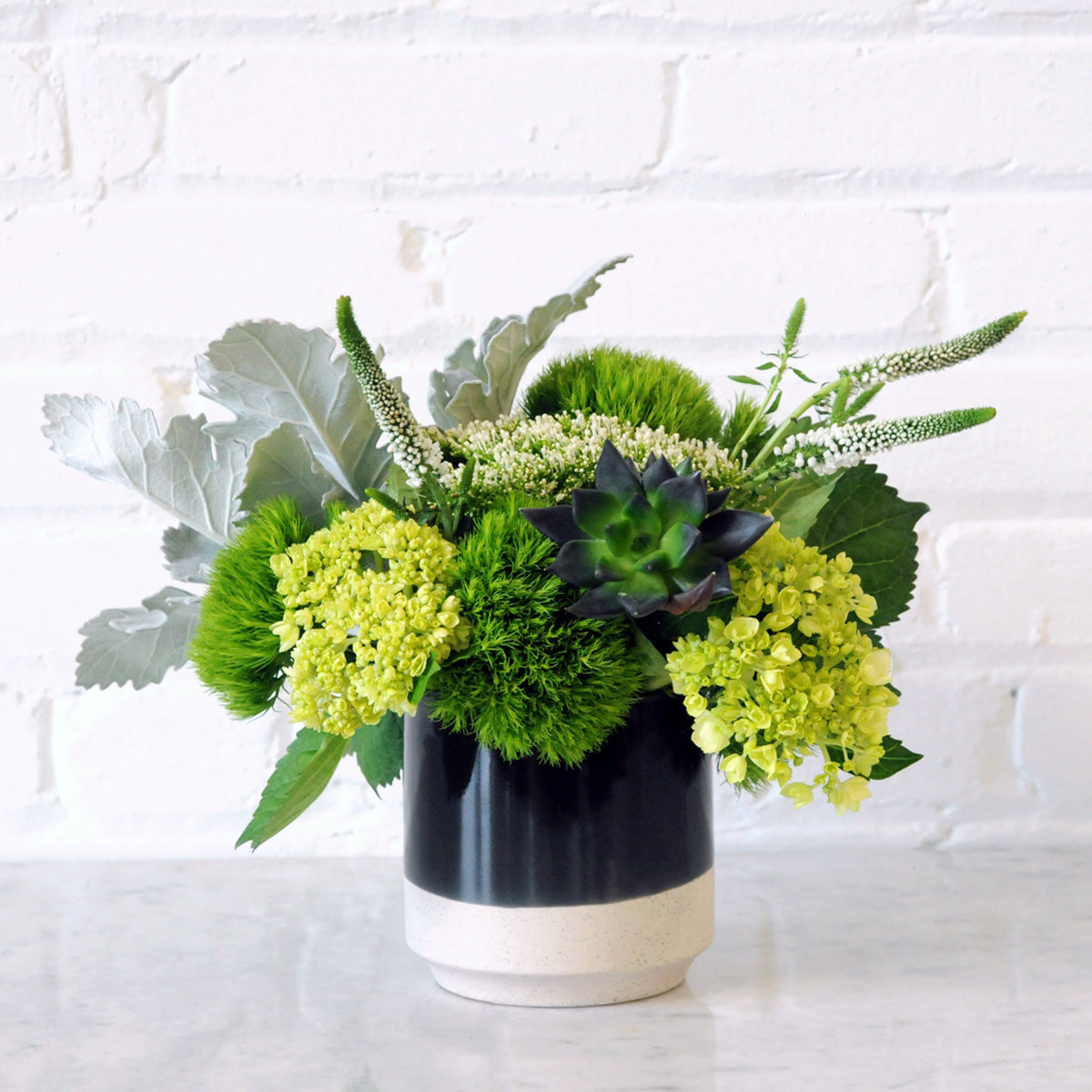 Spruce Flowers Loring arrangement in a two tone ceramic Miguel vase with Textural foliage