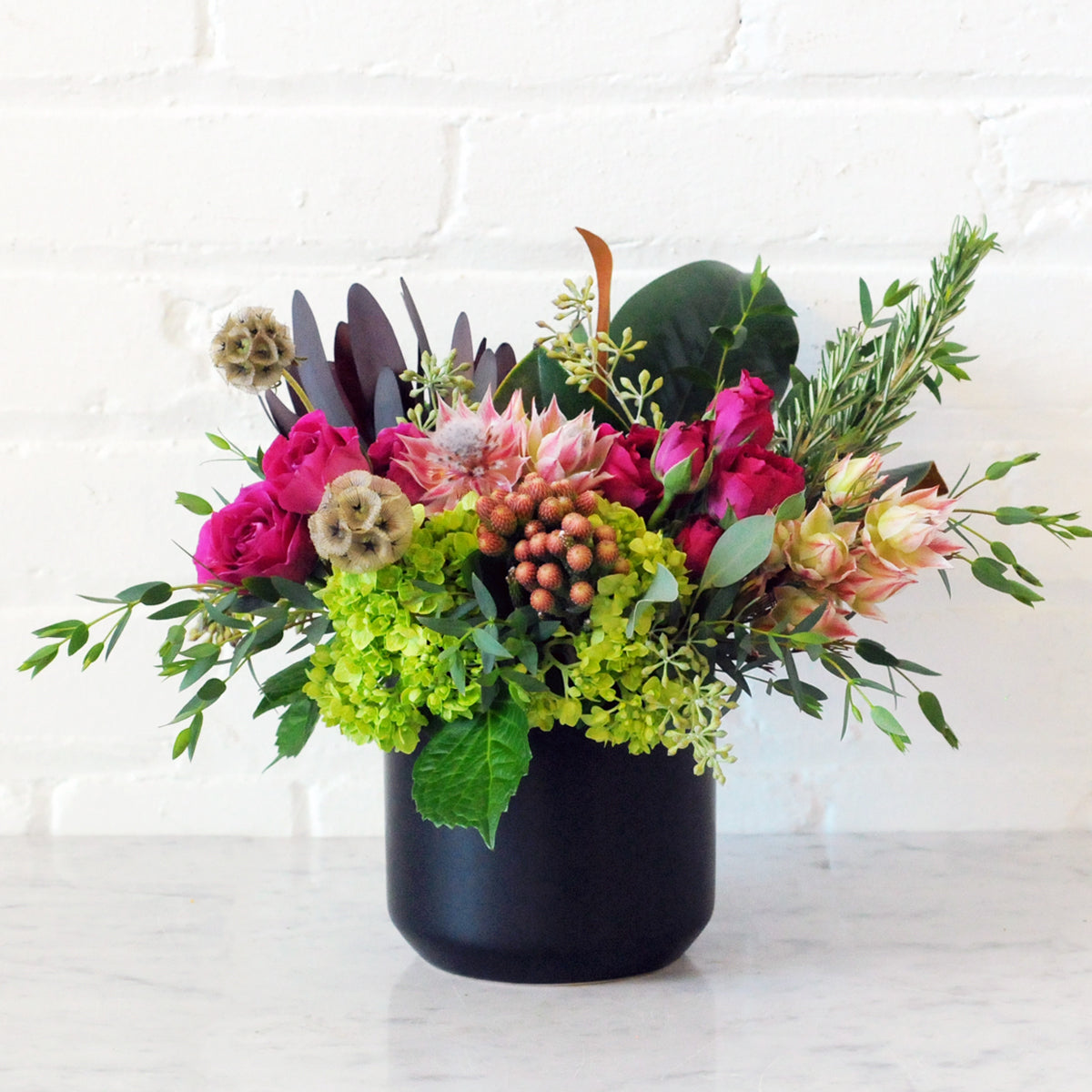 Fall tones flower arrangement in Black ceramic vase