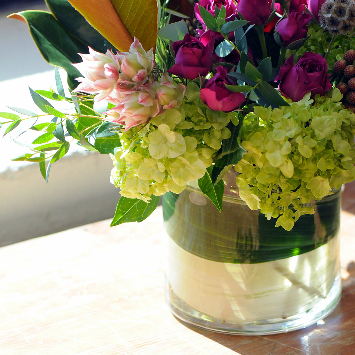 Bouquet of flowers in a clear vase on a wooden surface