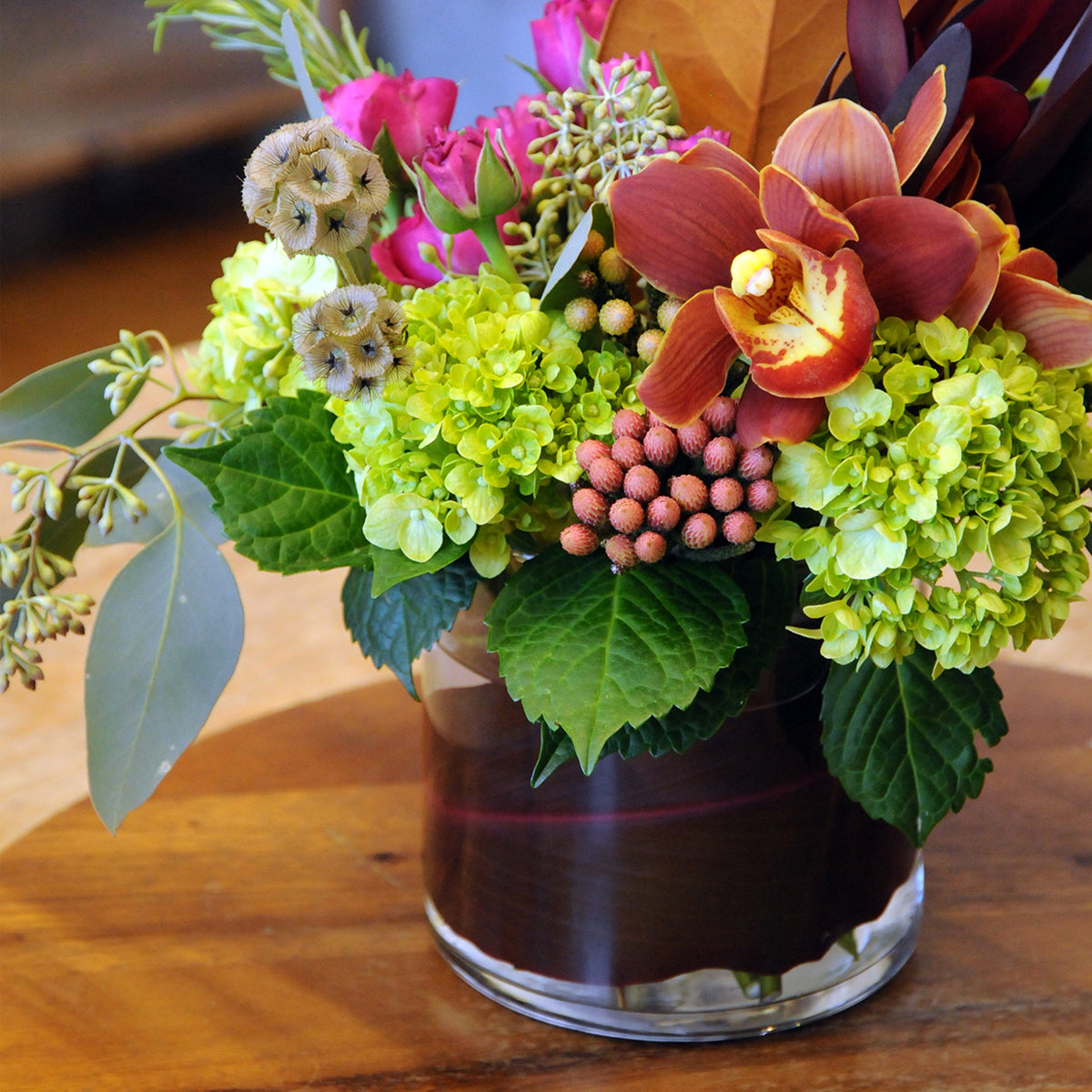 Colorful flower arrangement in a clear vase on a wooden surface