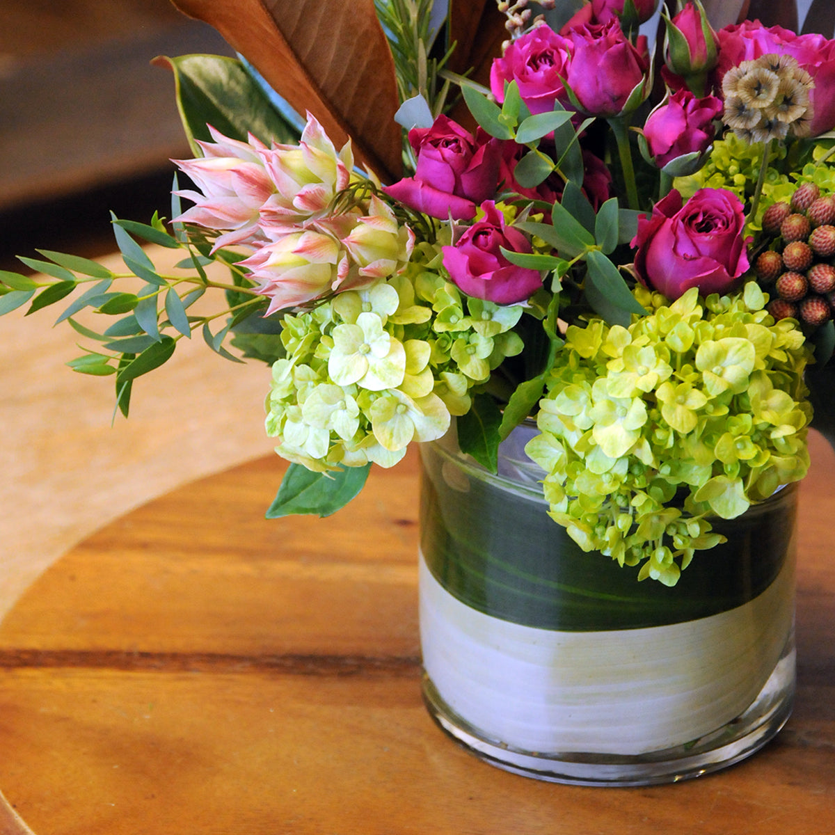 Floral arrangement in a glass vase on a wooden table