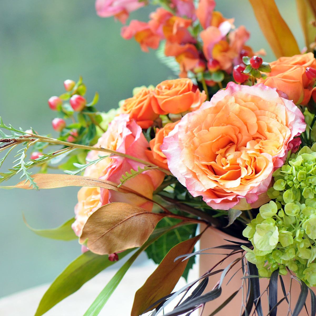 Close up of the Marshall arrangement showing a Free Spirit Roses in peach and range tones