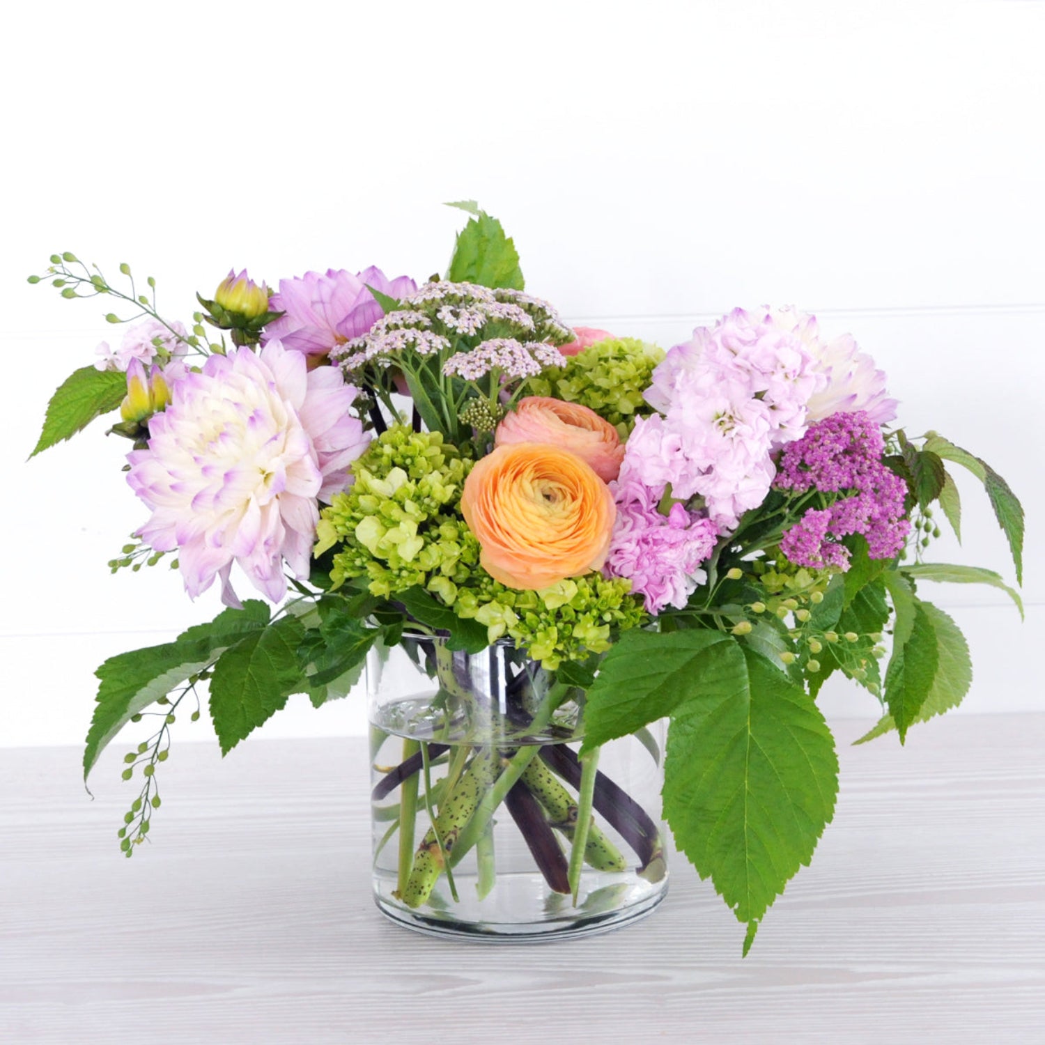 Our Buchanan Floral arrangement a celebration of summer featuring Dahlias shown here in Pastel shades, arranged in a whimsical style with other locally grown seasonal elements