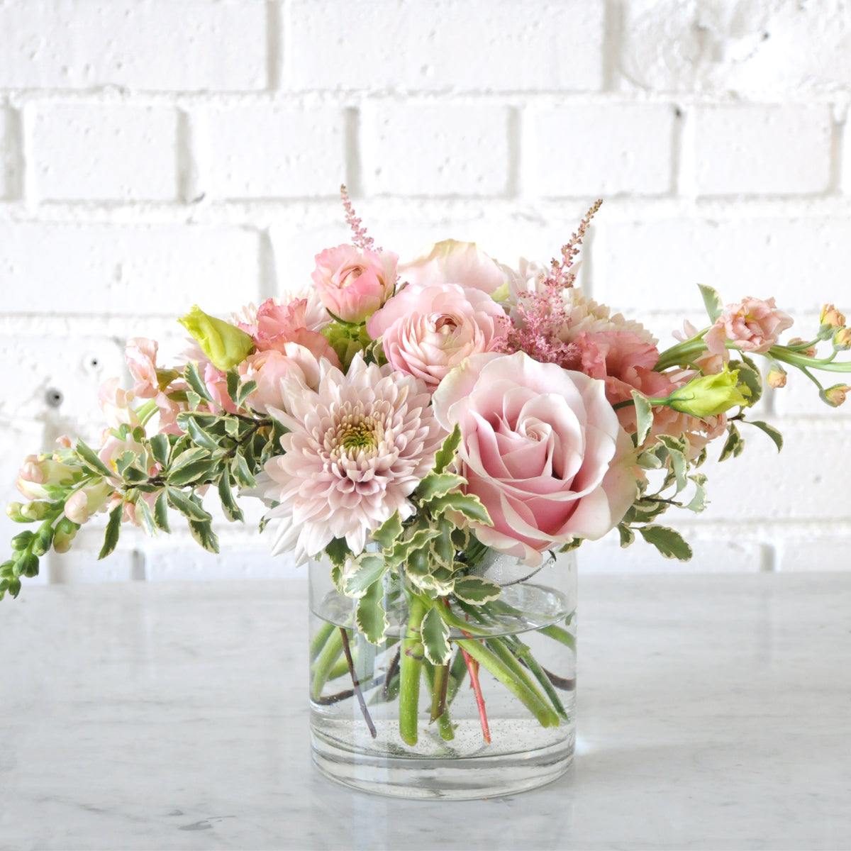 Pink and pastel florals classically styled Creative Director in a glass vase, image is an example of the styling rather than the exact arrangement that will be sent