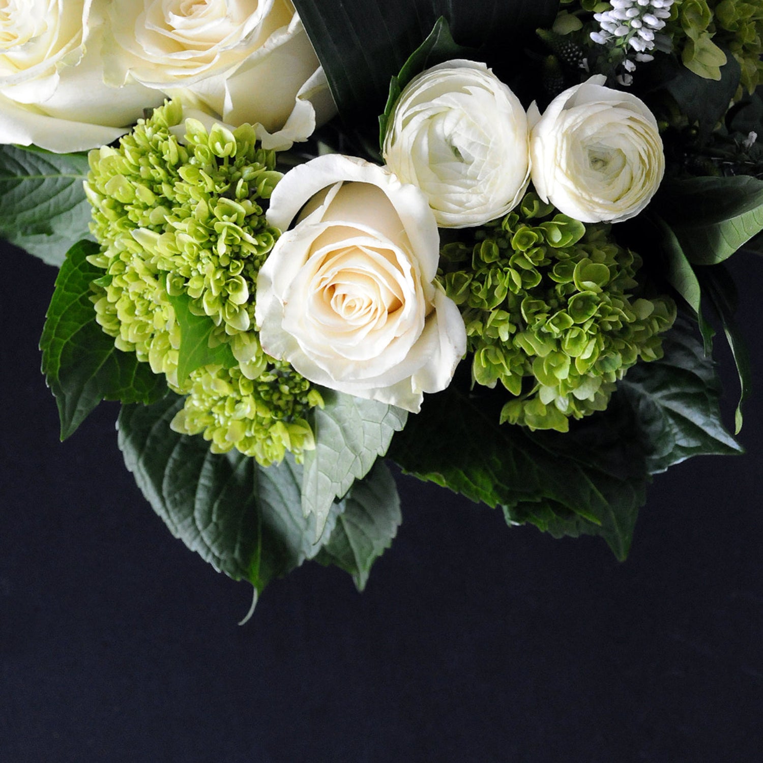 White Florals with a mixture of green foliage on black background