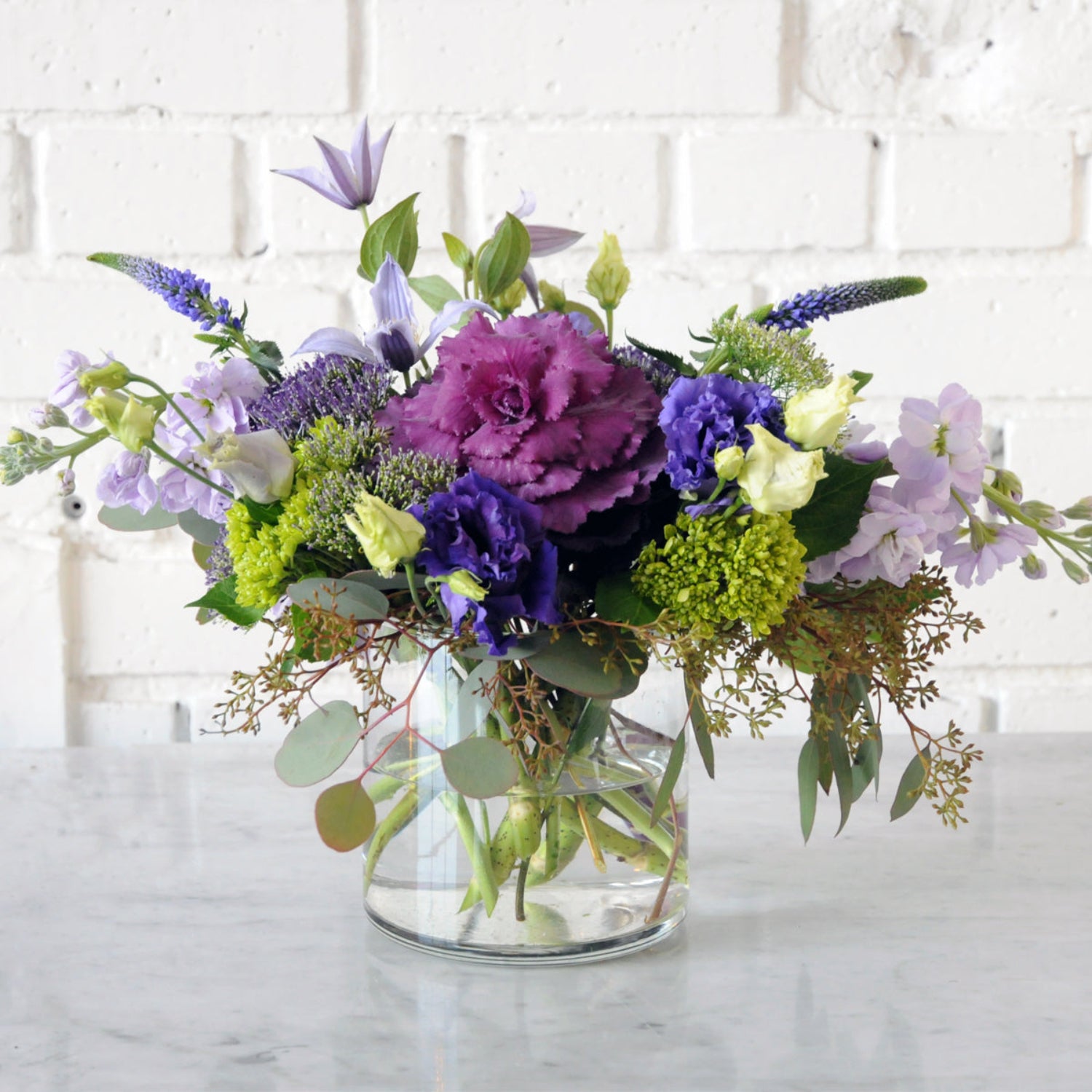 Creative Director Whimsical with purple Kale and lilac Stock with purple Lisianthus. Image is an example of the styling rather than the exact arrangement that will be sent