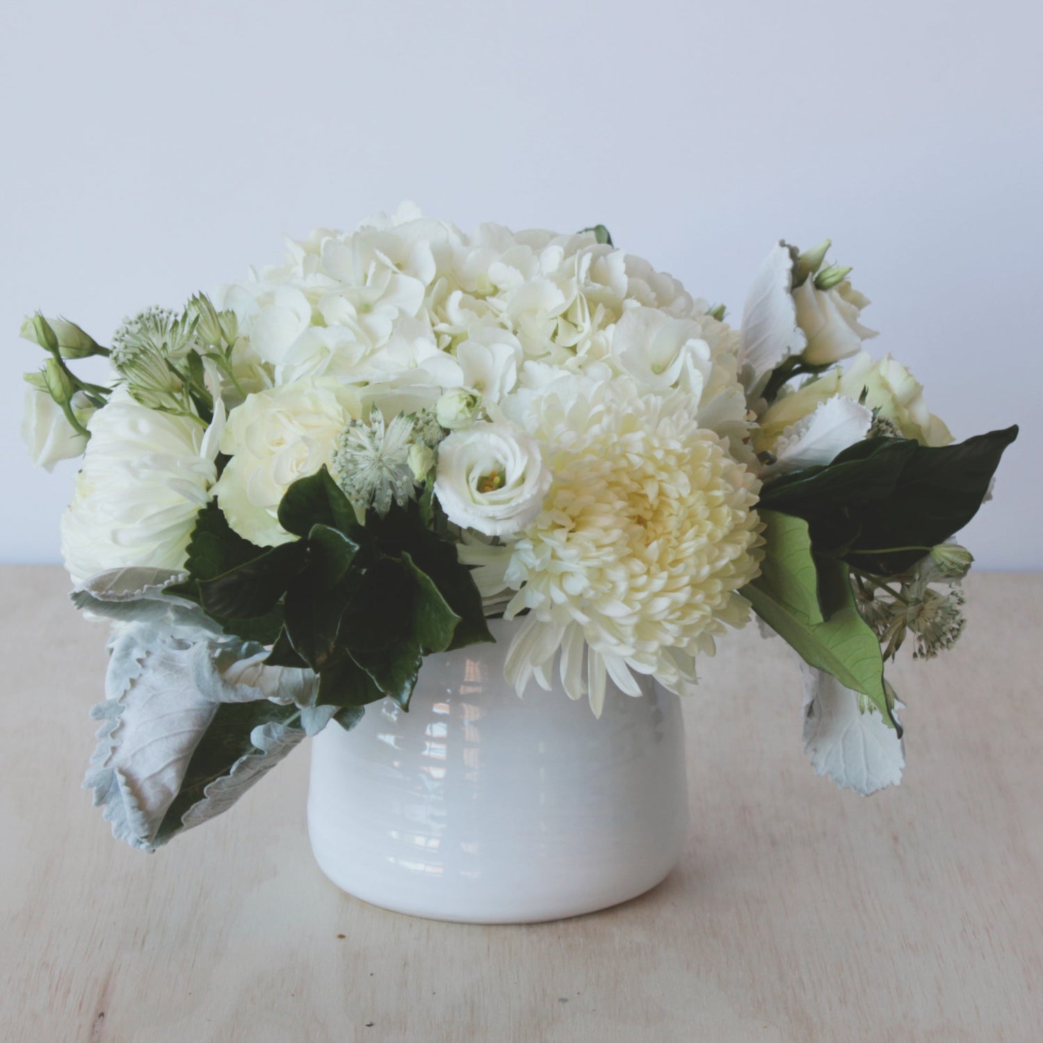 Monochromatic white floral arrangement is a white textured ceramic vase