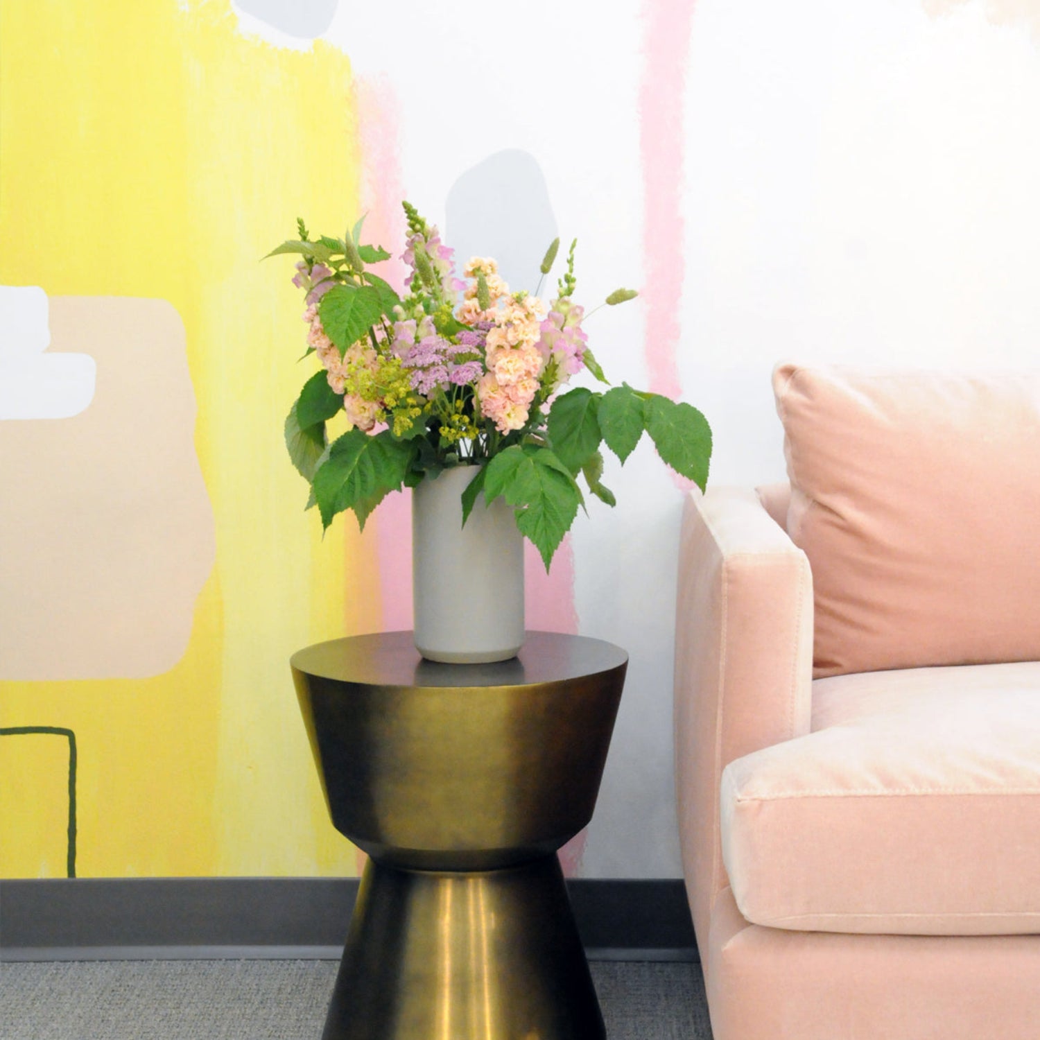 An example of the Larpenteur arrangement featuring yarrow, stock, and snapdragons shown on an end table in a living room setting