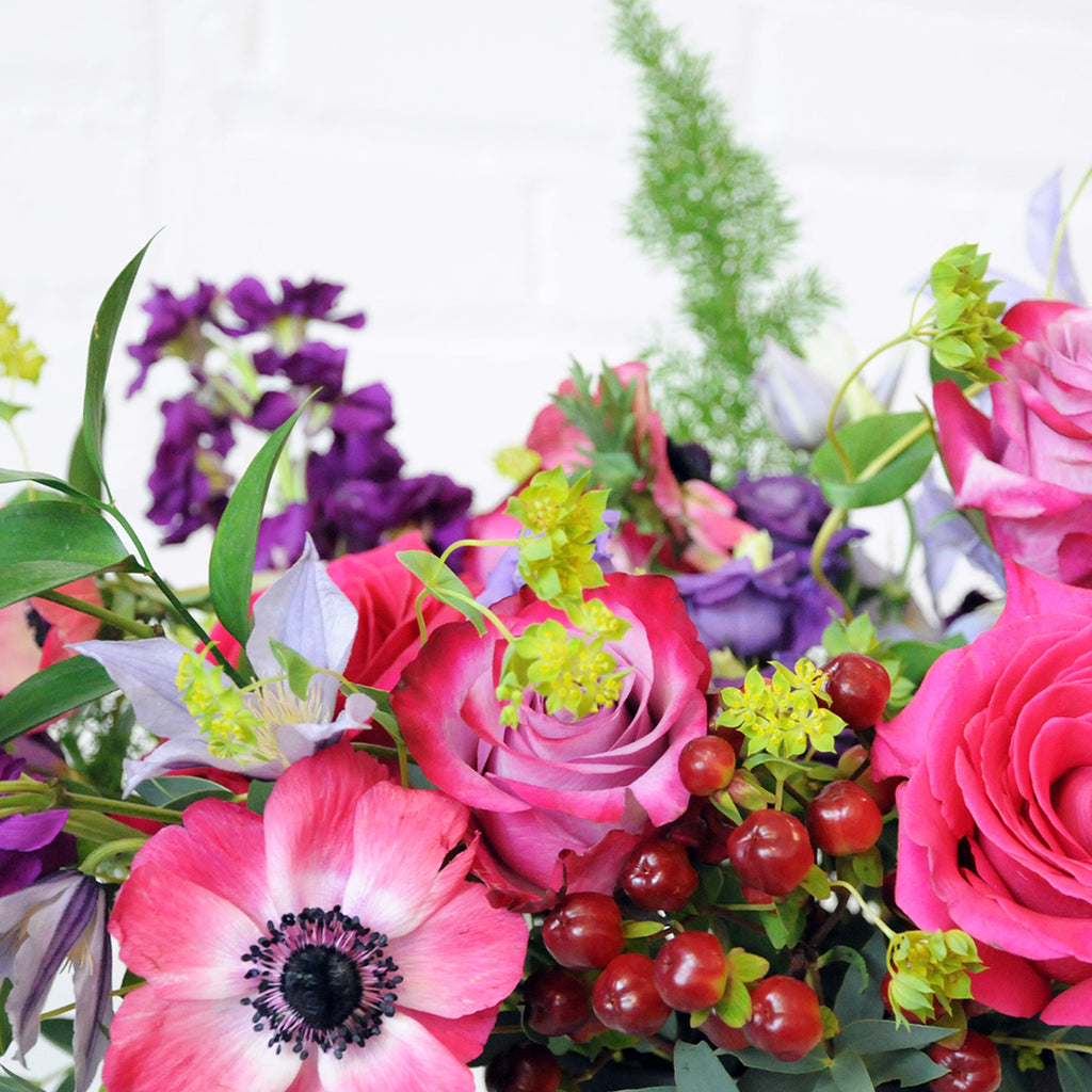 Close up of Aldrich Floral arrangement showing high mix of blooms in jewel tones 