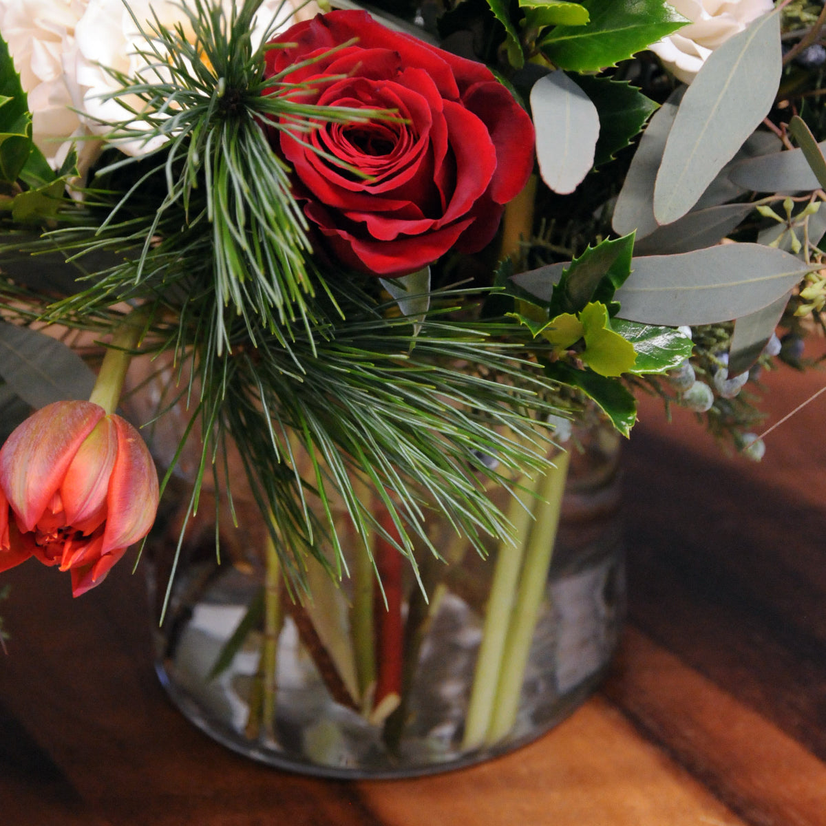 Detail of foliage and floral elements and glass vase