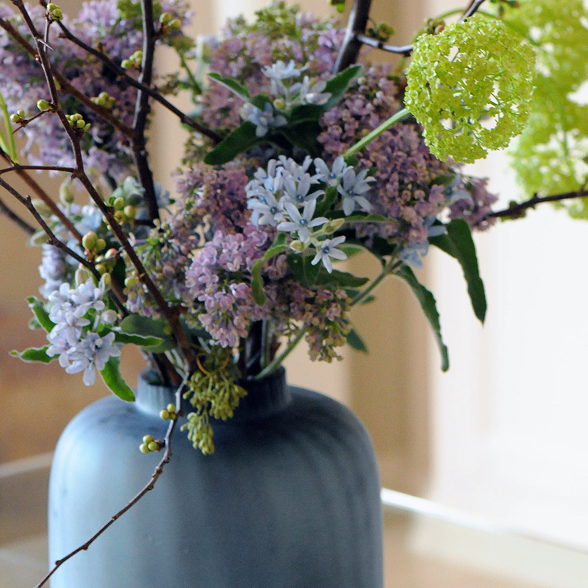 Blue vase with flowers on a blurred background
