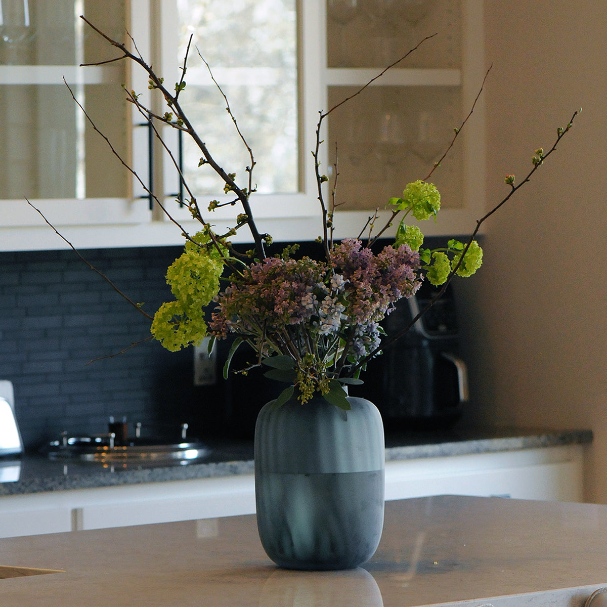 Vase with flowers on a kitchen counter