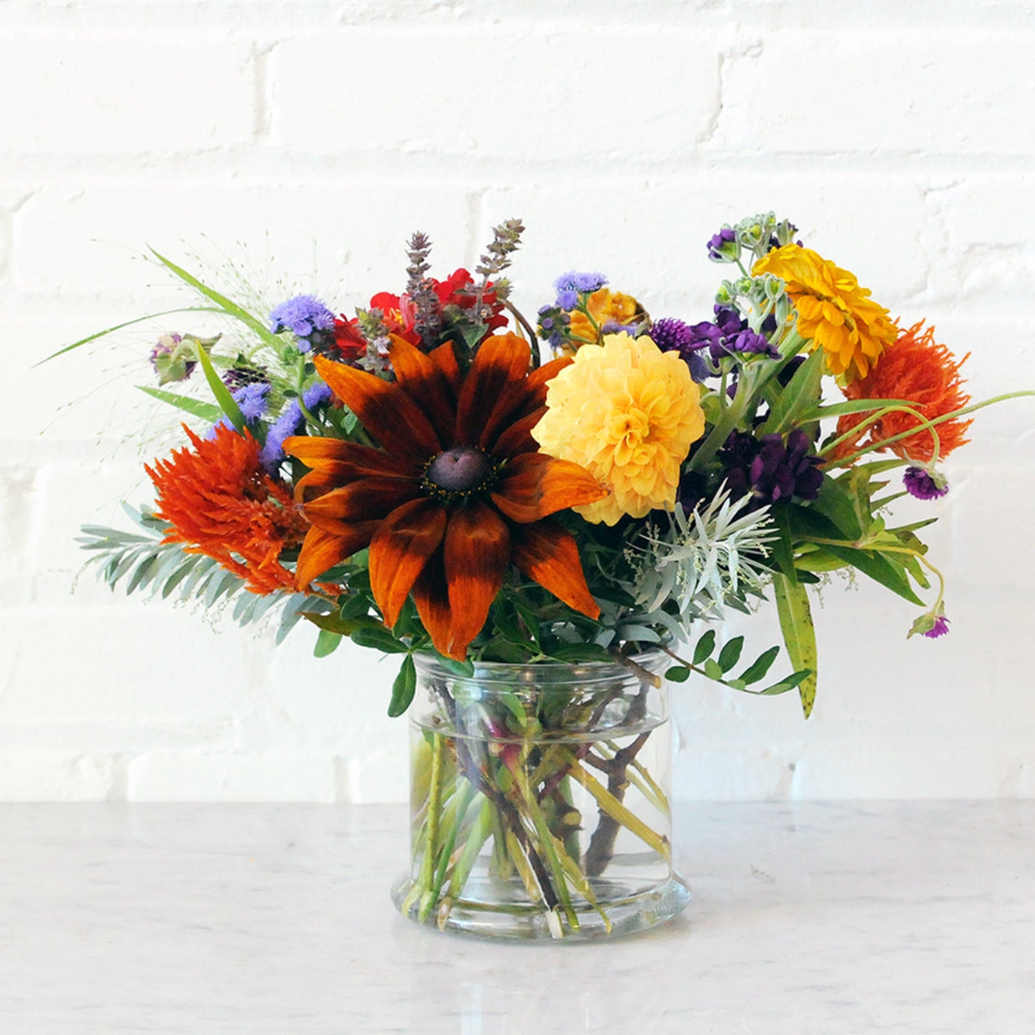 An example of the Larpenteur arrangement featuring summer favorites in a classic glass cylinder