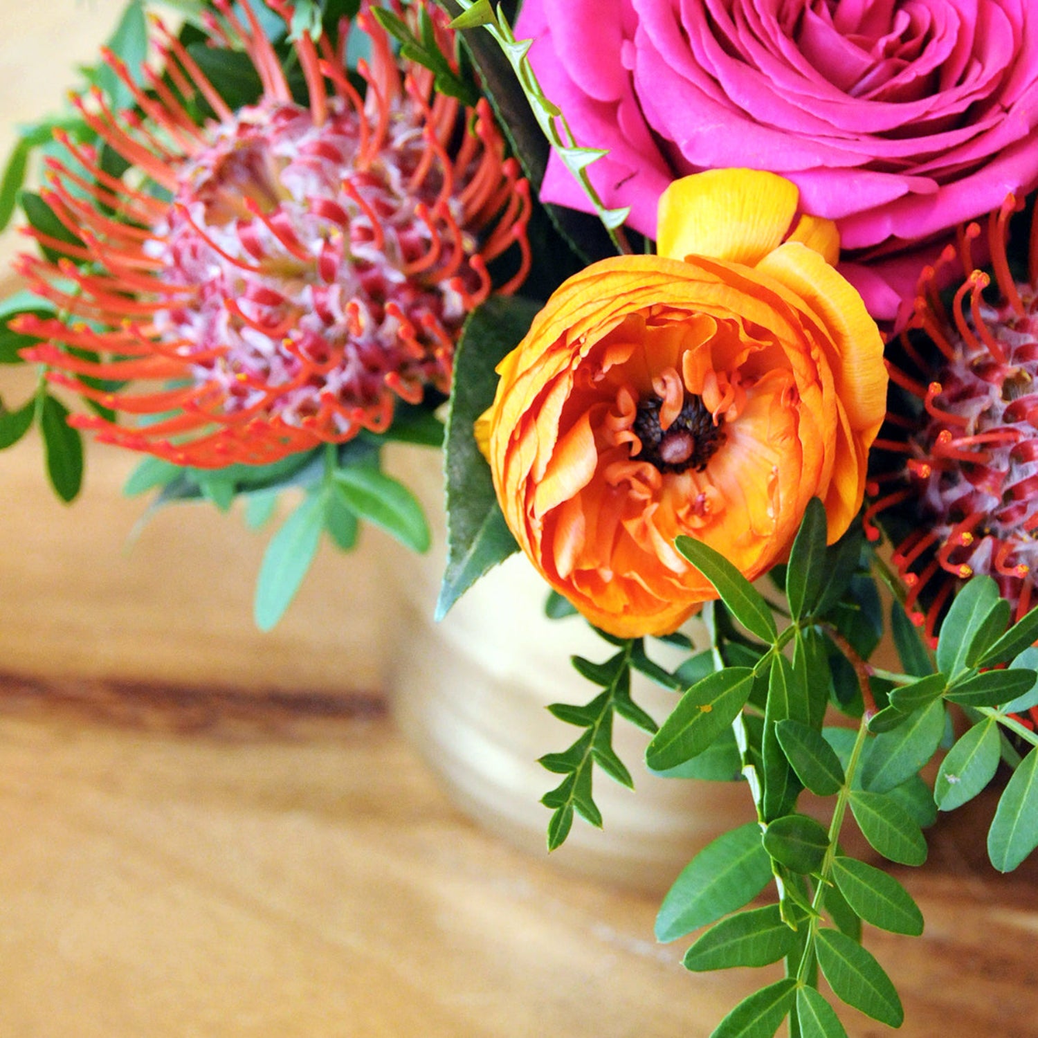 Close up image showing orange ranunculus featured in Spruce Flowers Lexington arrangement