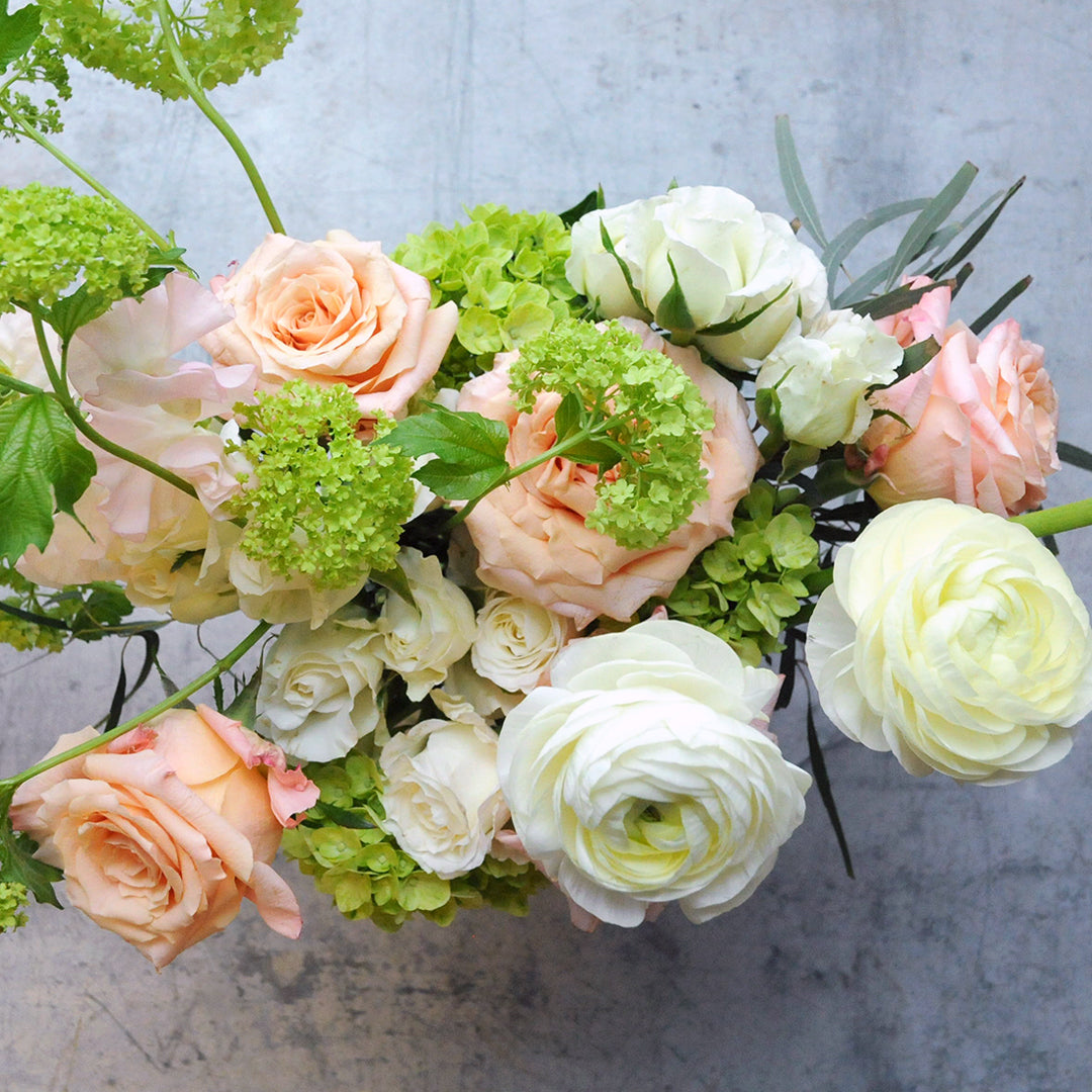 Top down view of the Lyndale Floral arrangement with Peach  and White Roses and Lime green Hydrangea  