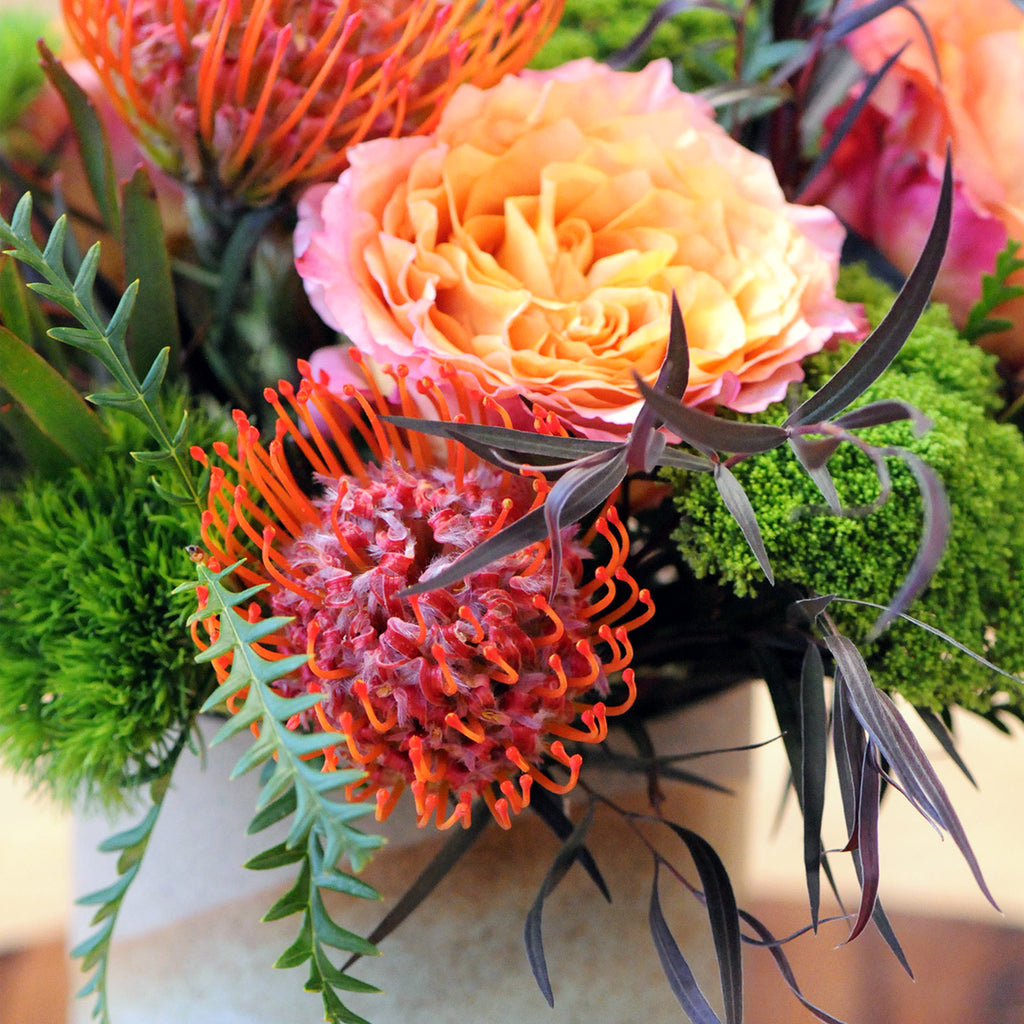 Close Up photo of Parkway floral arrangement showing Red Protea Flowers and Textural Foliage 