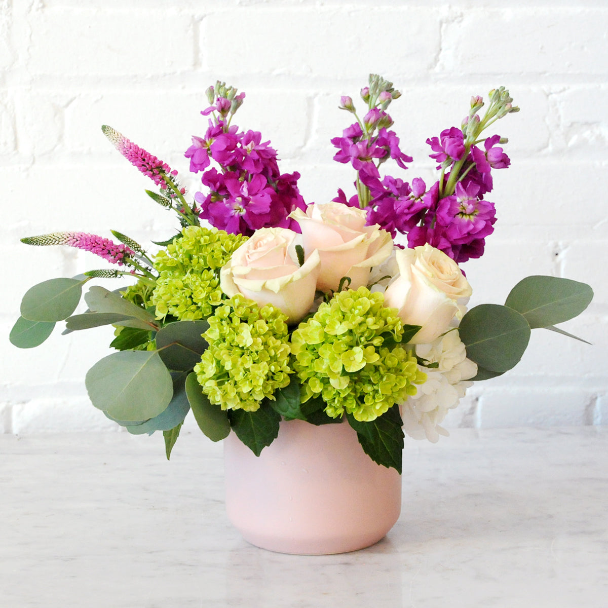 Spruce Flowers : Fresh Floral arrangement called Queen with soft pink Roses set on Hydrangea with cinnamon scented stock illustrated here in a blush Pink Kendal vase 