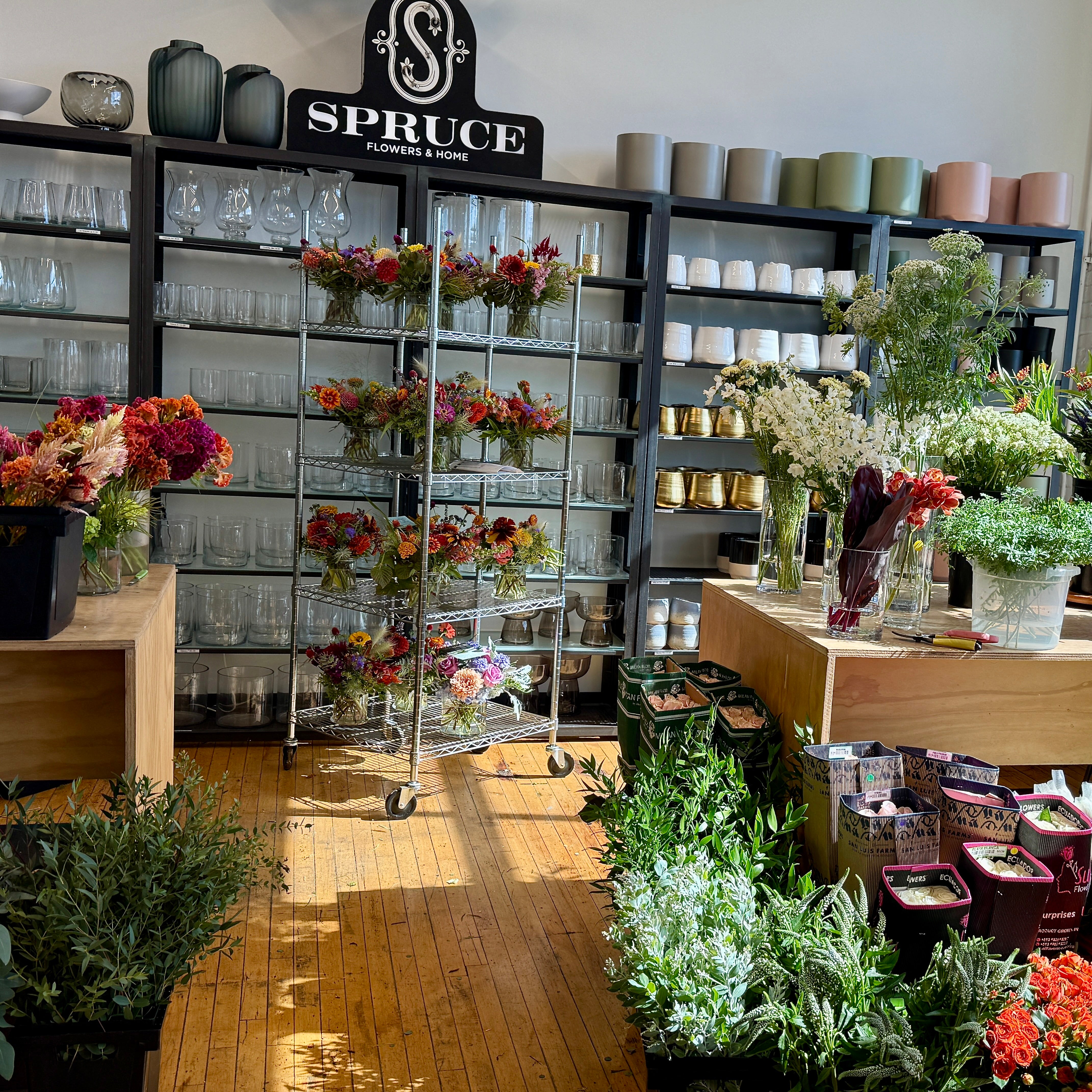 Spruce Flowers Studio interior with shelves displaying flowers and vases.