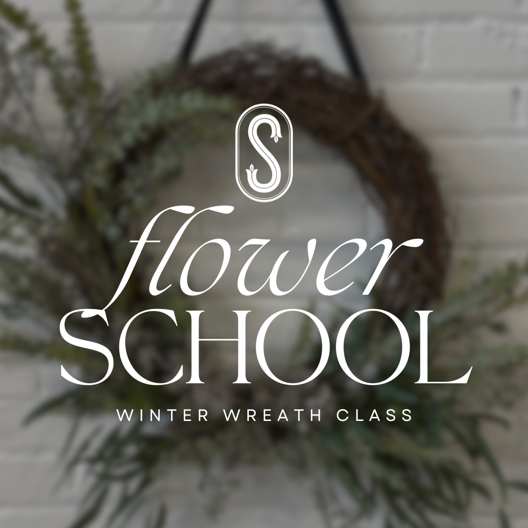Floral wreath with 'flower school' text overlay on a blurred background