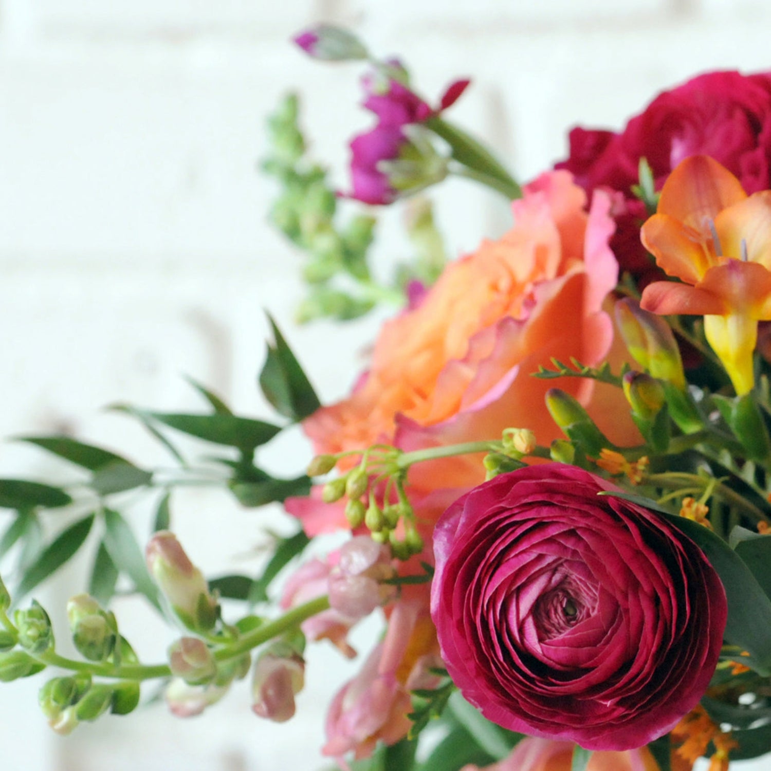 Close up of Ranunculus and Free Spirit Rose. Image is an example of the styling rather than the exact arrangement that will be sent 