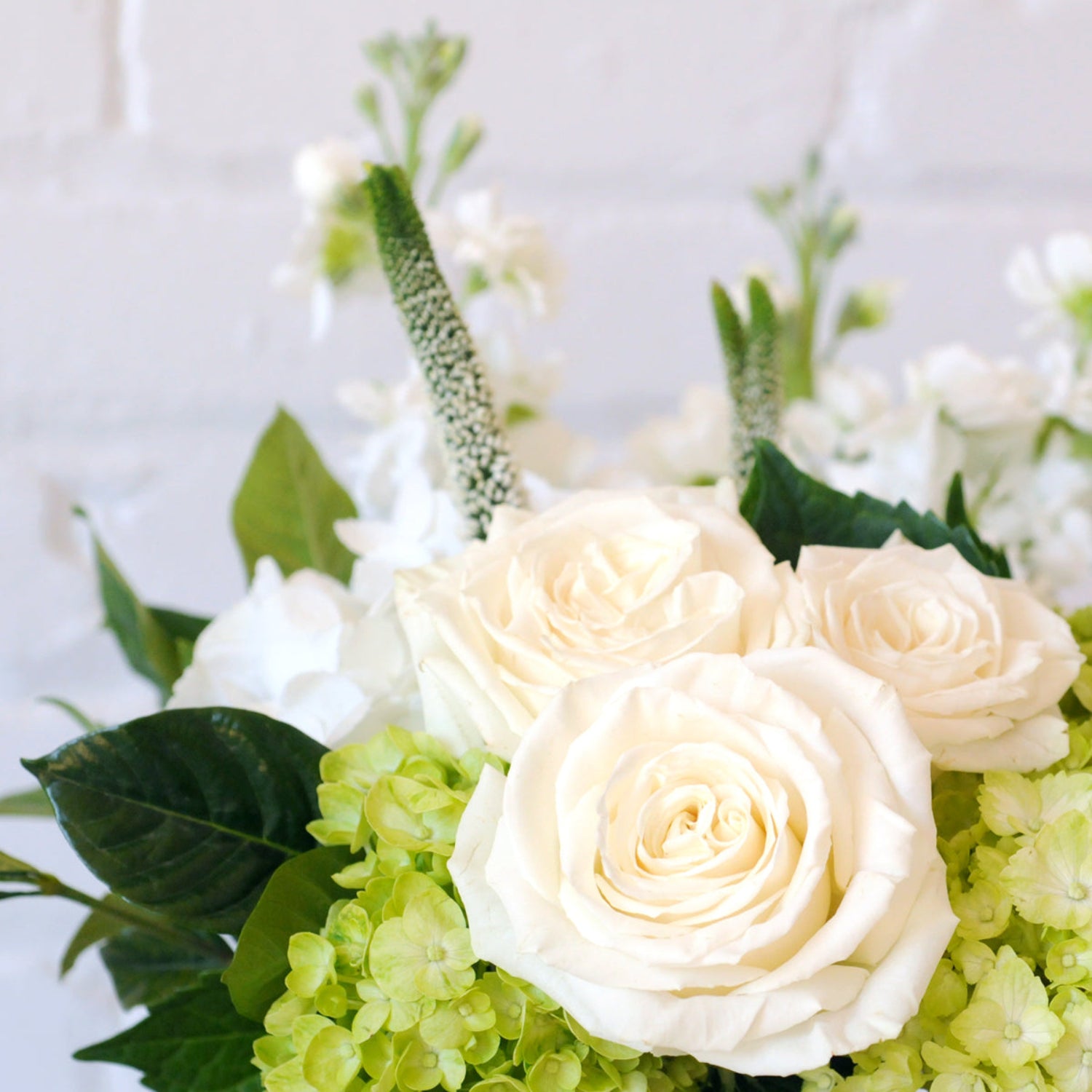 Detail view of white roses featured in Spruce Flowers Duke arrangement 