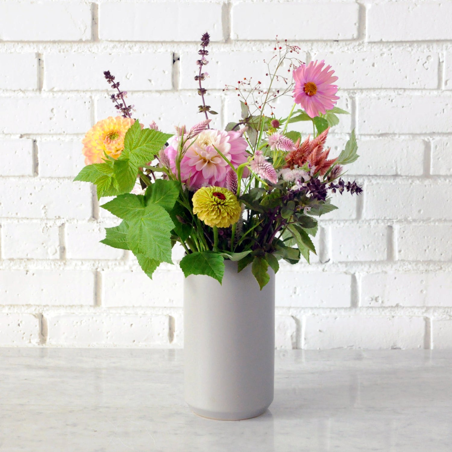An example of the Larpenteur arrangement featuring dahlias shown in a gray tall ceramic vase